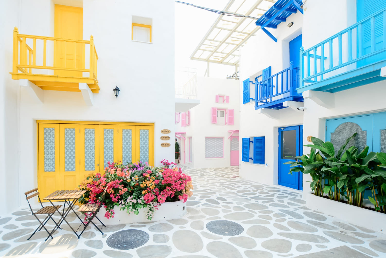 case in stil grecesc, fatada casa albastra, fatada casa galbena, plante, flori colorate