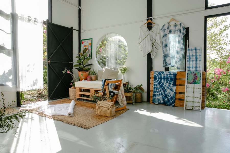 camera de zi cu deschidere spre natura, oglinda rotunda de perete, materiale textile, multe plante